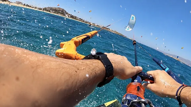 Les mains de Frédéric sur la barre de kitesurf, en navigation